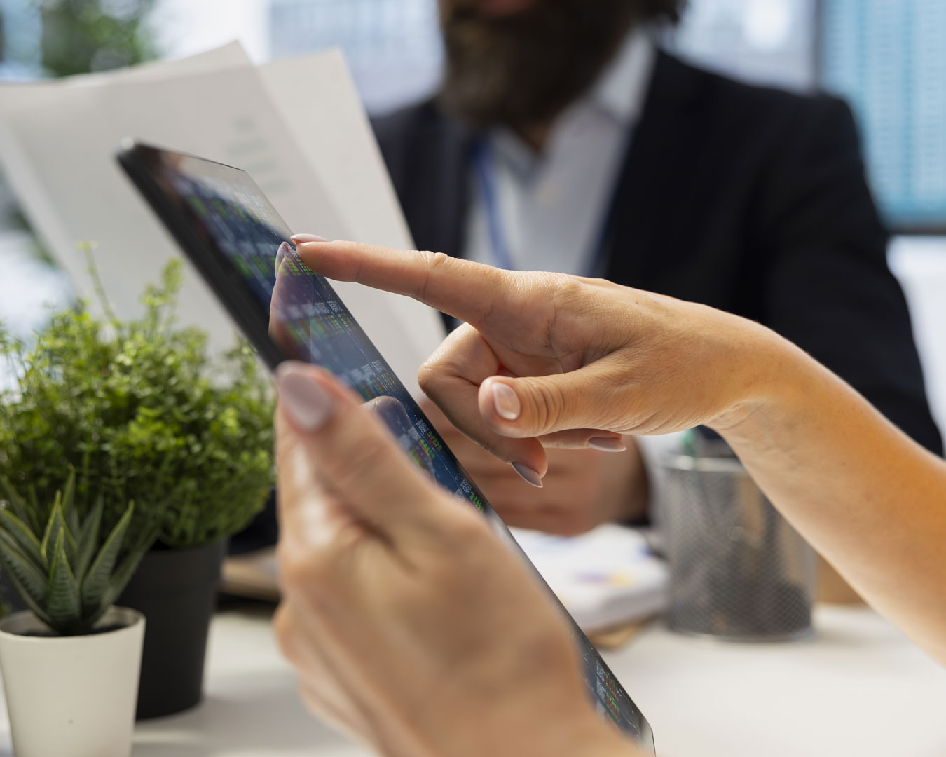 Agent offering advice on buying and selling stocks on tablet online, close up